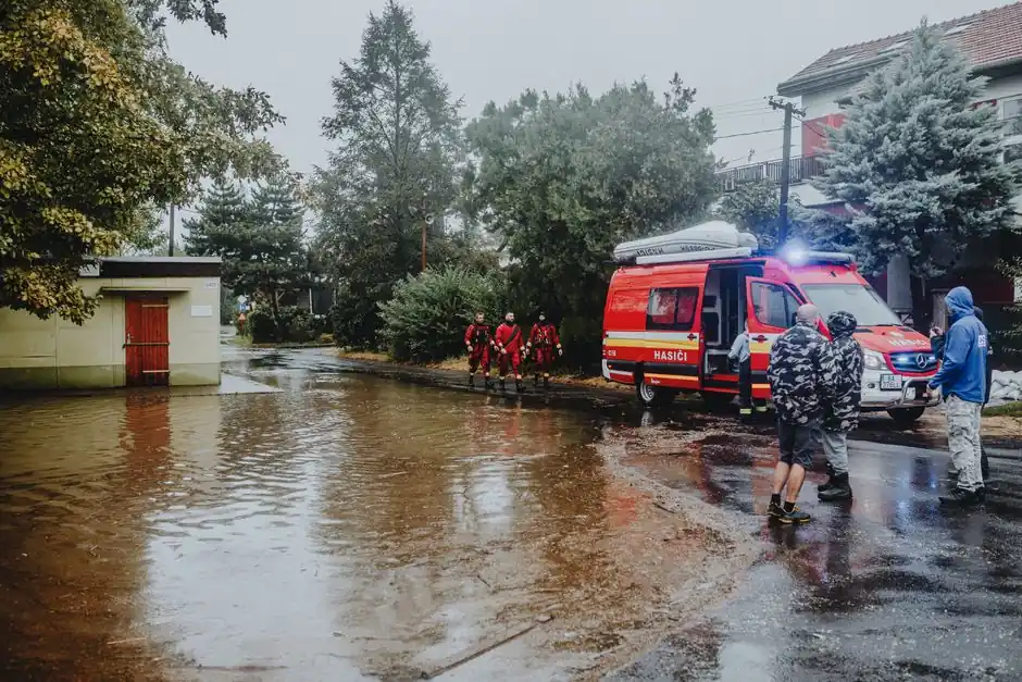 Emergency personnel managing flood with rescue vehicle. Urban scene with standing water.