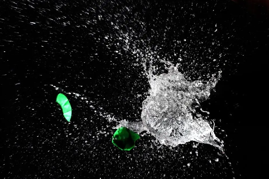 High-speed capture of a water balloon bursting, revealing dramatic splash against a dark background.